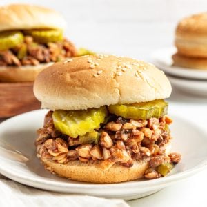 Plant-based sloppy joe meat served with a bun and pickles.