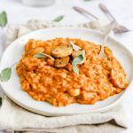 A plate of pumpkin sage risotto garnished with sage leaves.