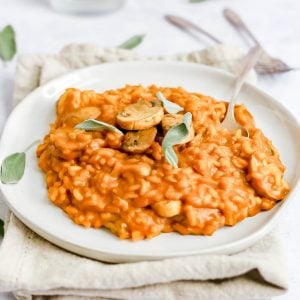 A plate of pumpkin sage risotto garnished with sage leaves.