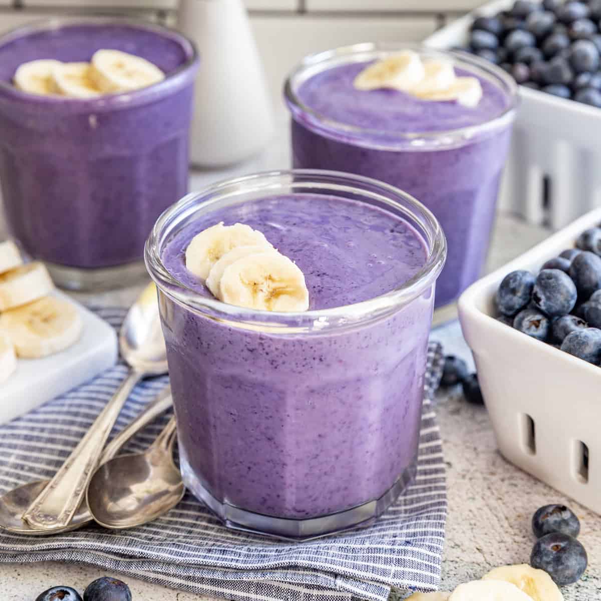 Three glasses of silken tofu smoothies, garnished with banana slices.