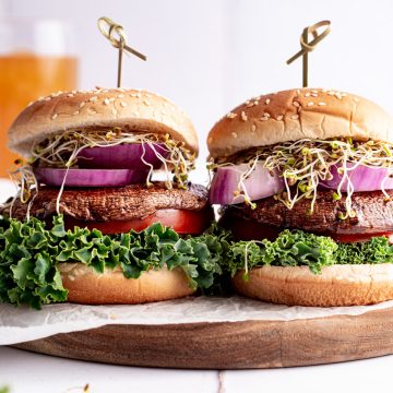 Two smoked maple portobello burgers on a cutting board.