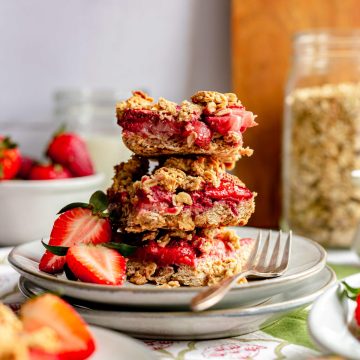 A stack of vegan strawberry crumble bars on a plate.