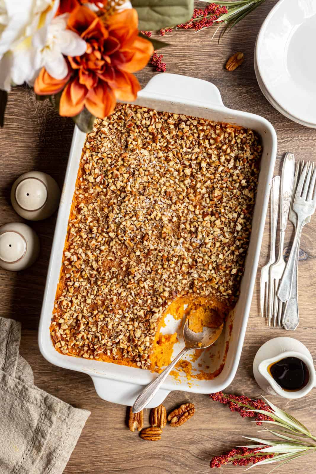 A dish of sweet potato casserole with a serving scooped out.