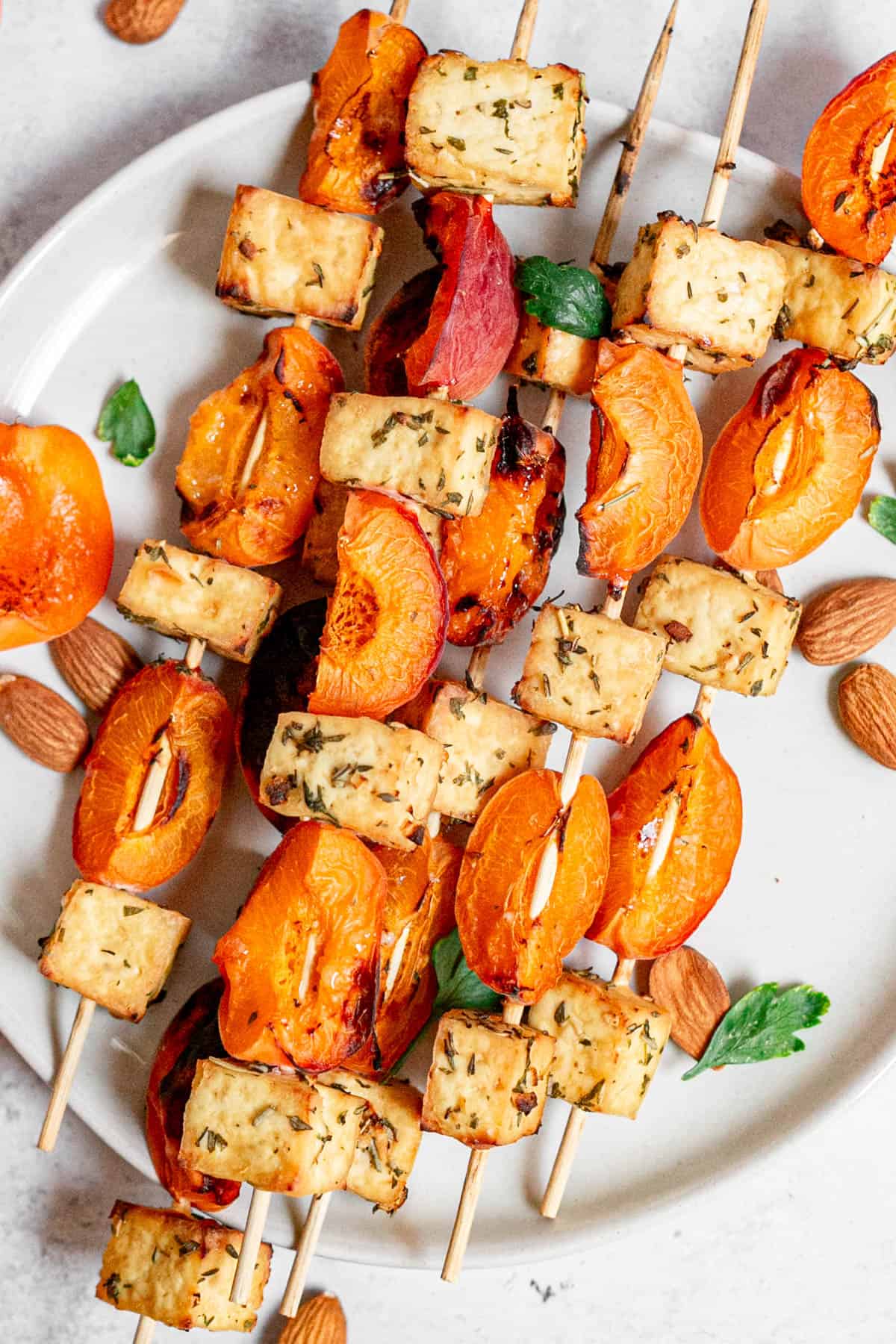 A plate of tofu apricot skewers, garnished with fresh herbs.