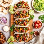 A cutting board lined with tofu crumble tacos.