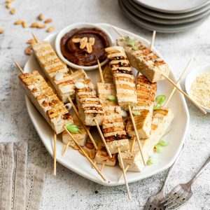 A tray of tofu satay skewers served with peanut sauce.