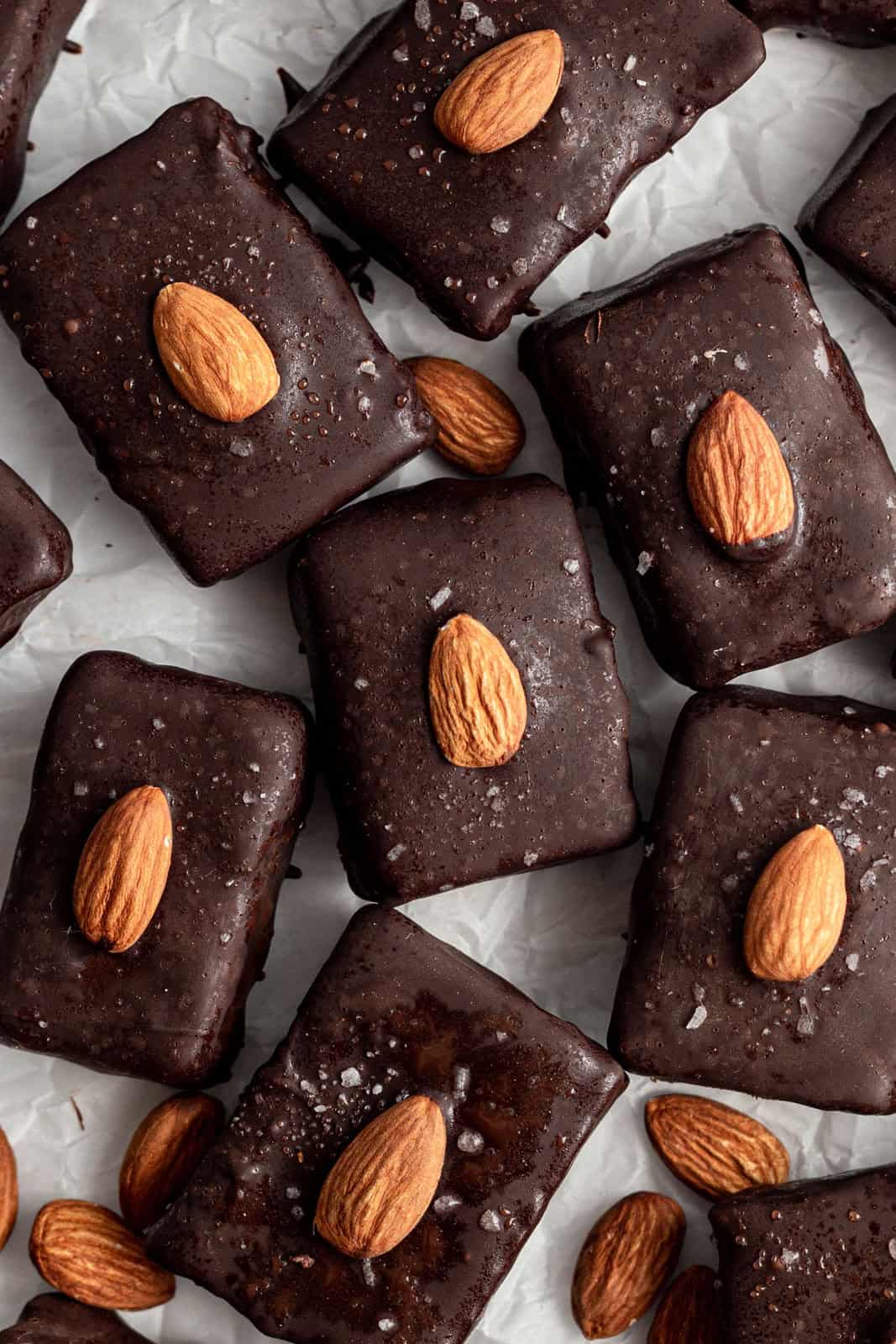 Several vegan almond joy bars on a sheet of parchment paper.