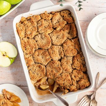 A dish of apple cobbler with a serving removed.