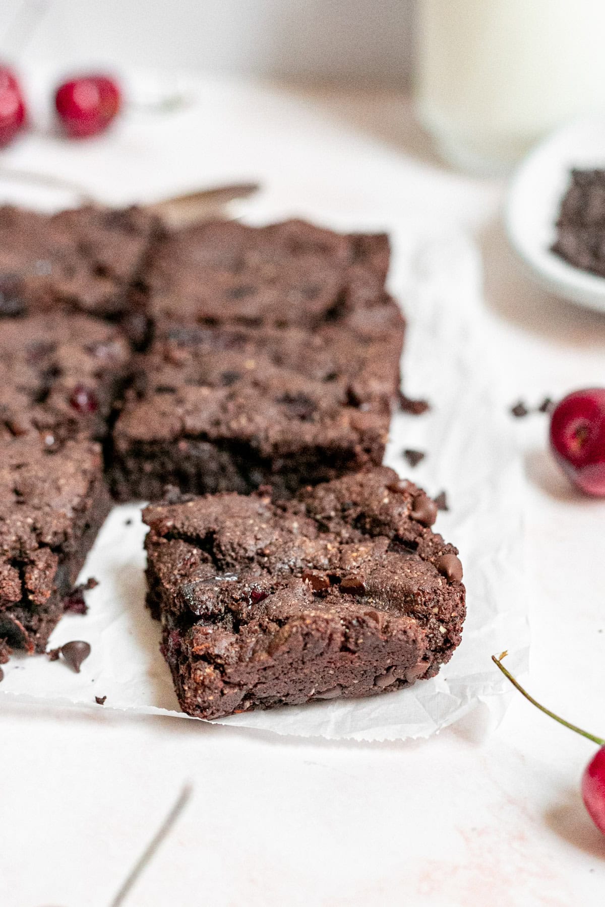 A cut brownie on a sheet of parchment paper.