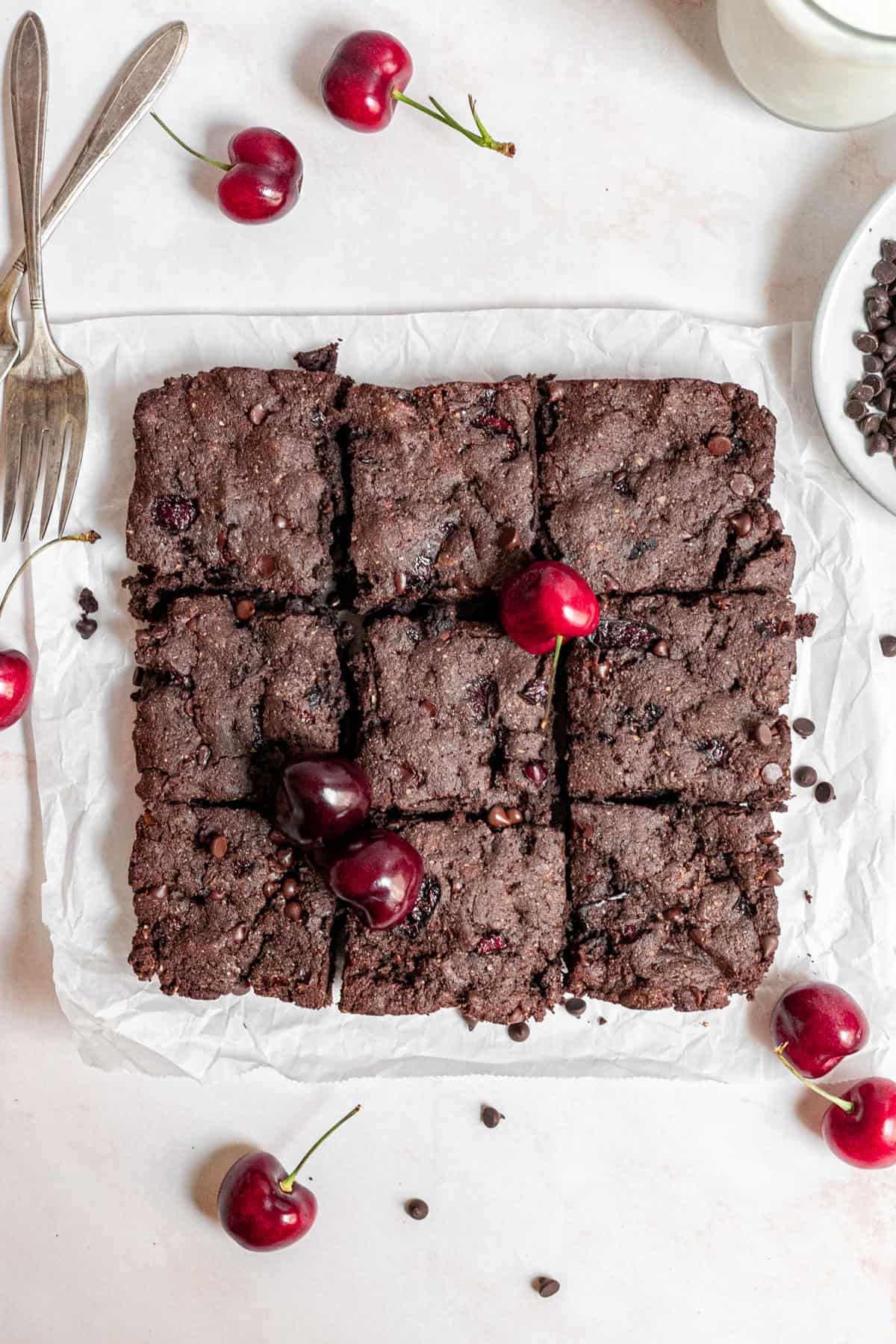 Freshly baked vegan black forest brownies on a sheet of parchment paper.