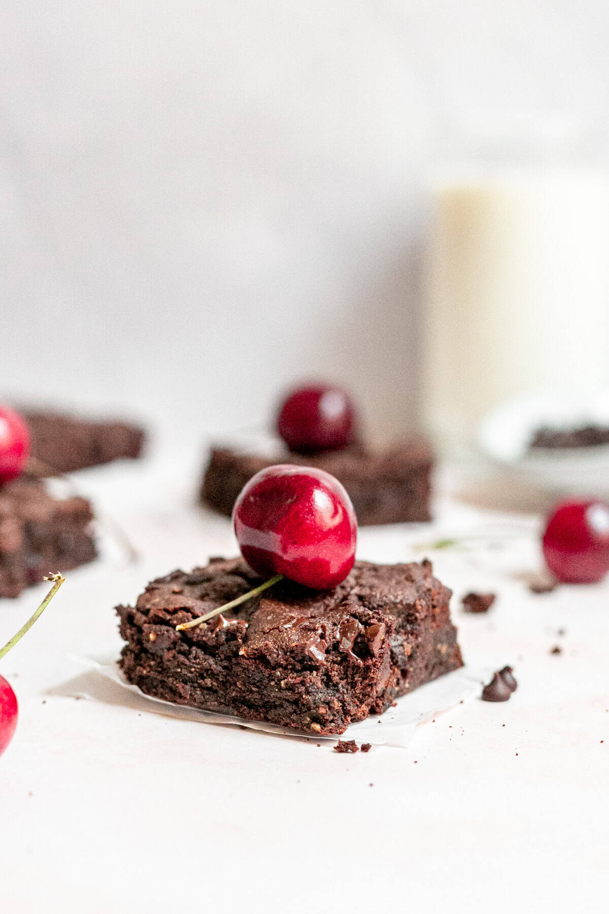 A vegan black forest brownie topped with a cherry.