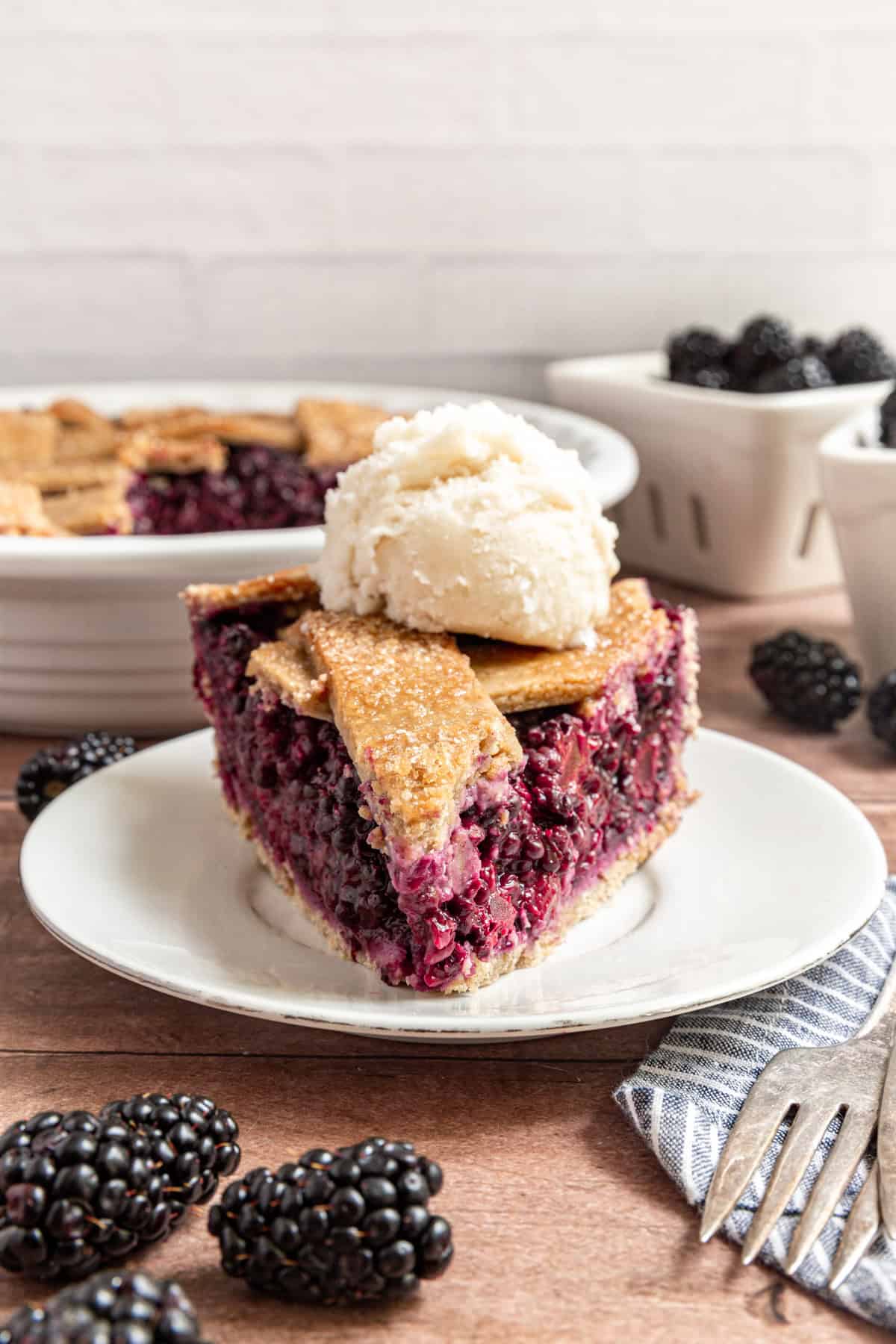 A slice of blackberry pie with a scoop of ice cream on top.