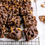 Sliced chocolate covered pretzel brownies on a cooling rack.