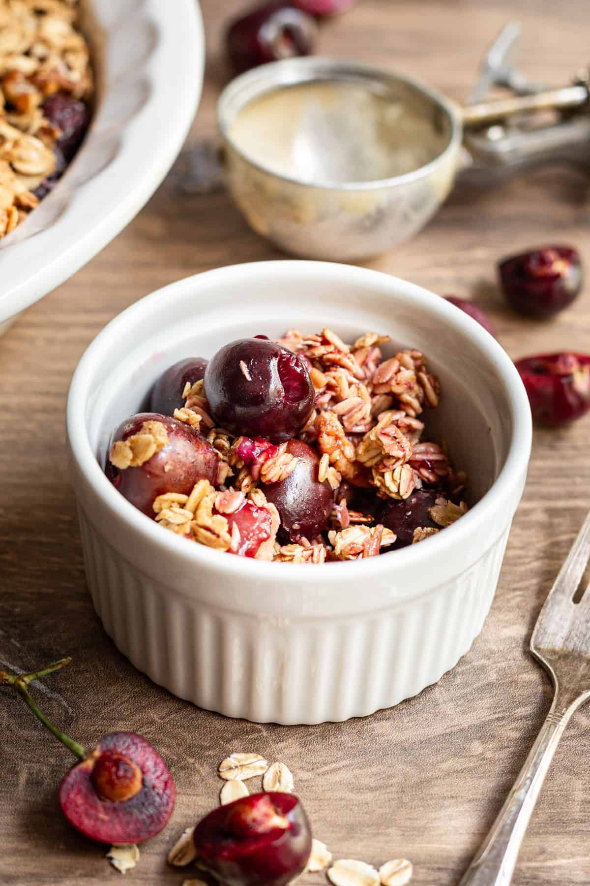 A serving of cherry crisp in a ramekin.
