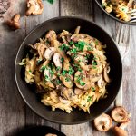 A bowl of vegan mushroom stroganoff served over gluten free pasta.