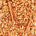 A tray of vegan honey roasted peanuts, with cinnamon sticks.