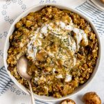 A bowl of vegan mushroom wild rice soup swirled with yogurt.