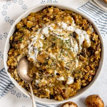 A bowl of vegan mushroom wild rice soup swirled with yogurt.
