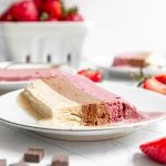 A slice of vegan neapolitan ice cream with a bite taken out.