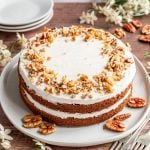 An iced vegan carrot cake, ready to serve.