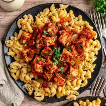 A plate of tofu paprikash, served with elbow noodles.