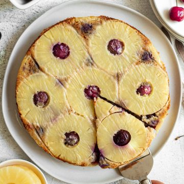A person pulling a slice of the pineapple upside down cake.