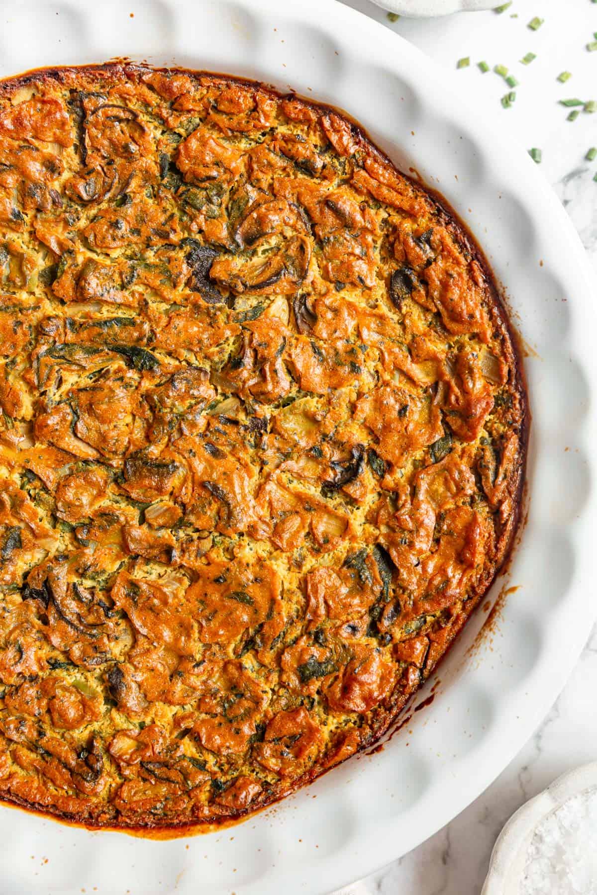 A Vegan Crustless Quiche ready to be topped with fresh chives.