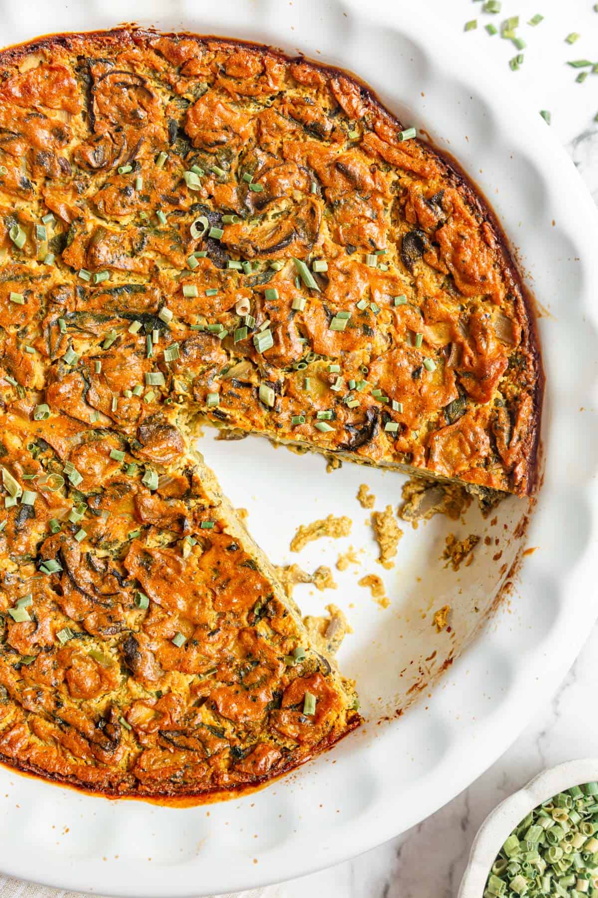 A slice removed from a freshly baked Vegan Crustless Quiche.