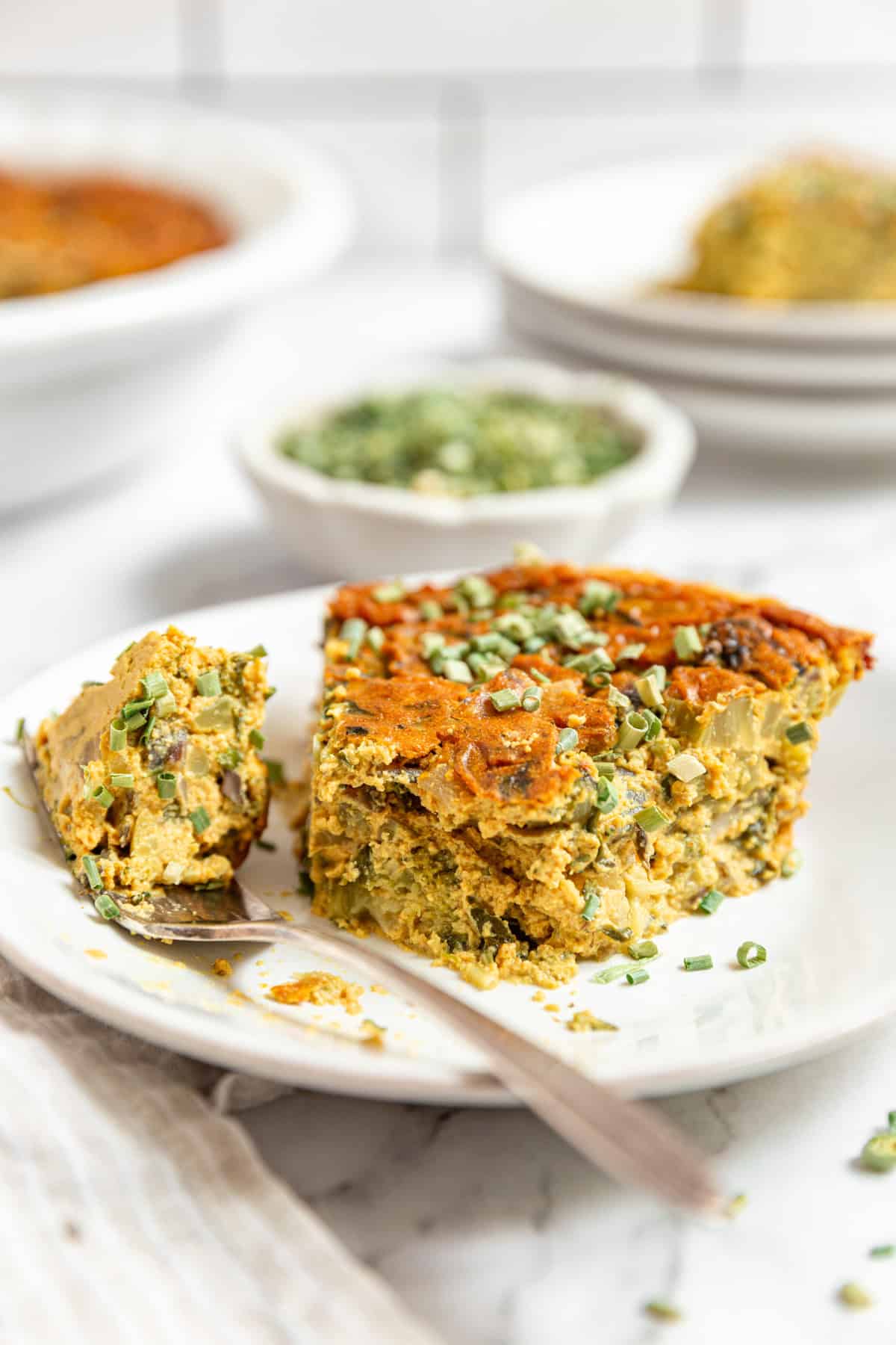 A bite taken out of a slice of Vegan Crustless Quiche.