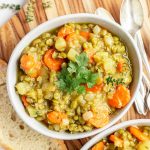 A bowl of vegan split pea soup, with bread, ready to serve.