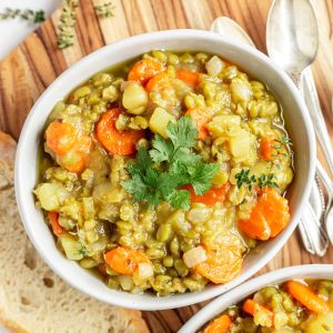A bowl of vegan split pea soup, with bread, ready to serve.