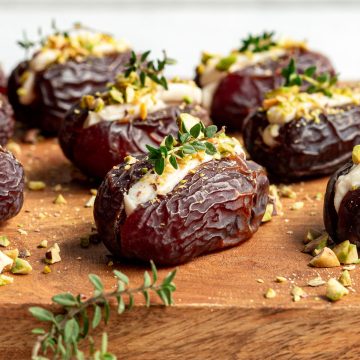 A tray full of stuffed dates, garnished with fresh thyme.
