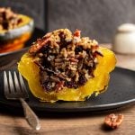 A wild rice stuffed acorn squash sliced in half to reveal the rice inside.