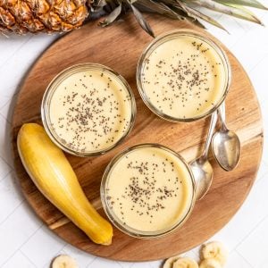 A platter with three yellow squash smoothies.