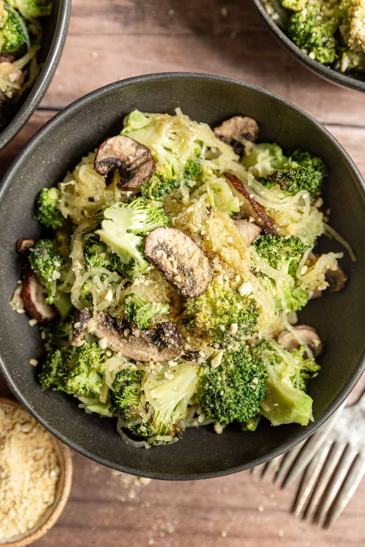 A bowl of Broccoli Parmesan Spaghetti Squash with Roasted Mushrooms.