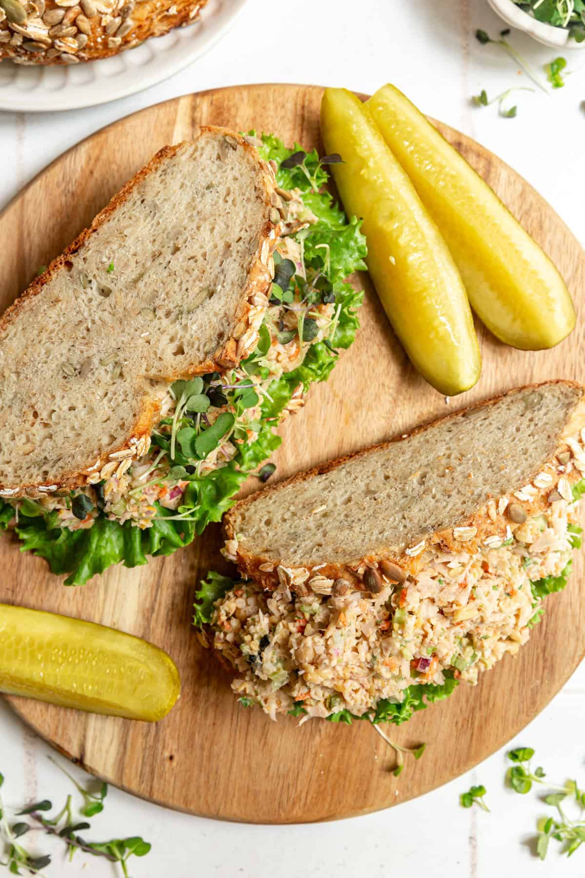 Two Jackfruit tuna salad sandwiches with pickles.