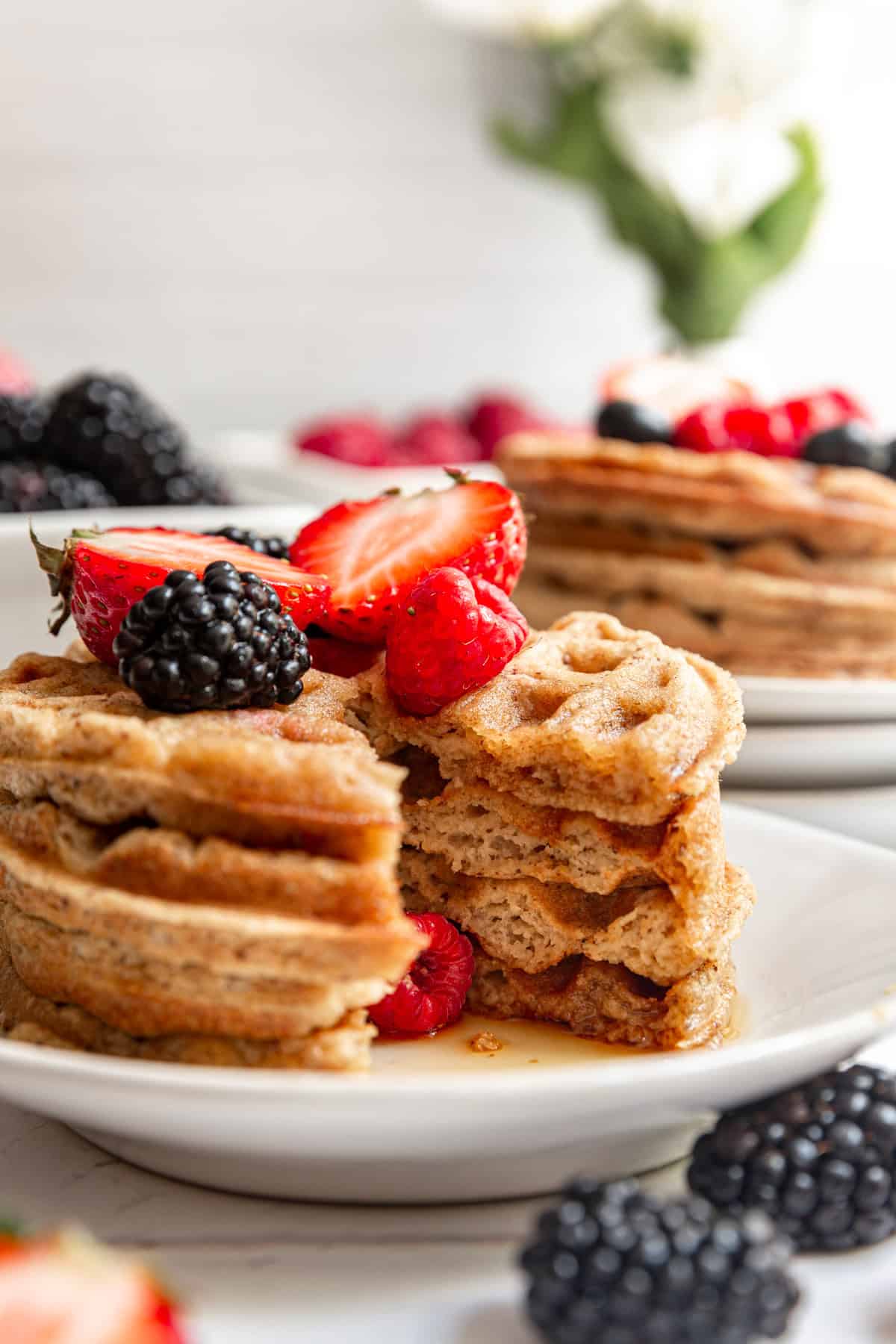 A stack of oat flour waffles with a triangle slice removed.