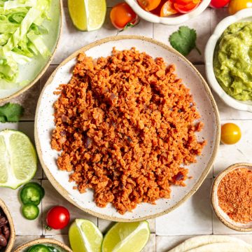 A bowl of TVP taco meat, with bowls of taco toppings.