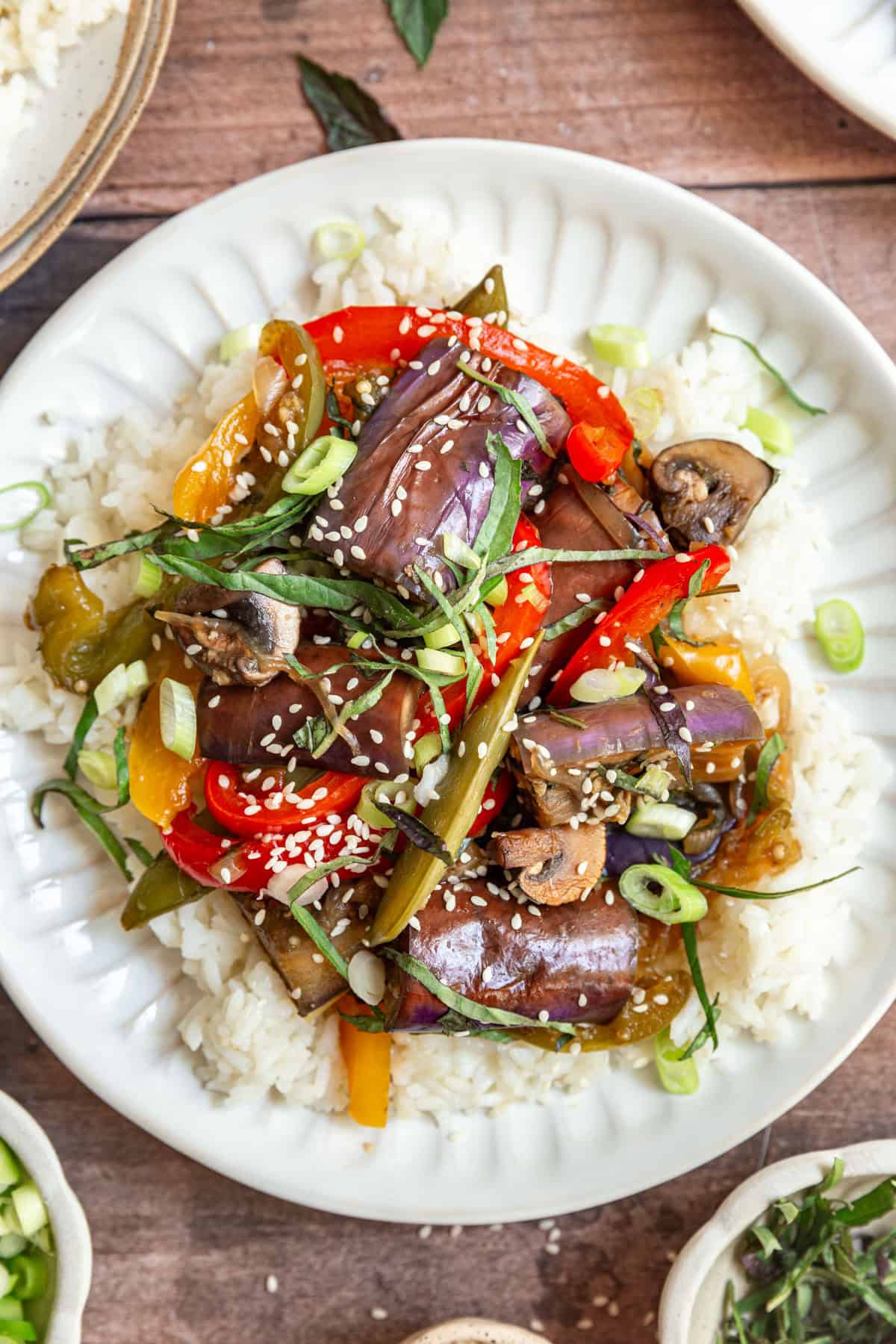 A plate of Thai Basil Eggplant Stir Fry served over rice.