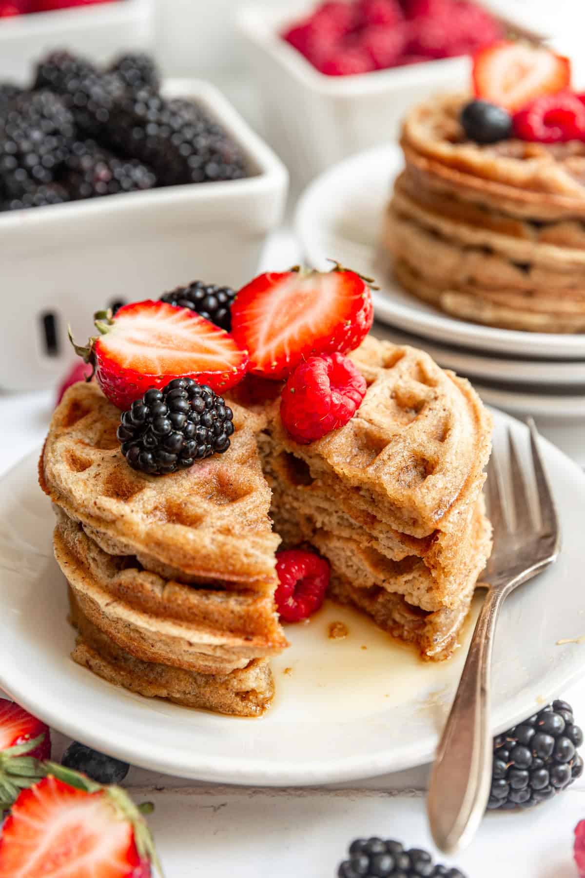 A stack of oat flour waffles with a triangle slice removed.