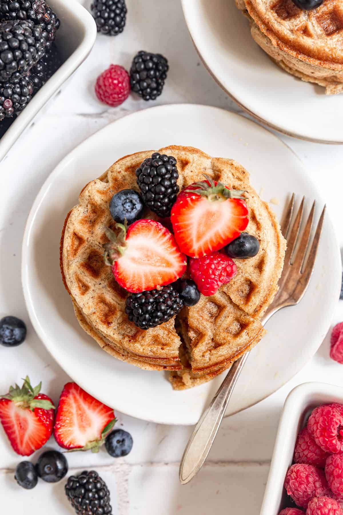 A stack of oat flour waffles with a triangle slice cut.