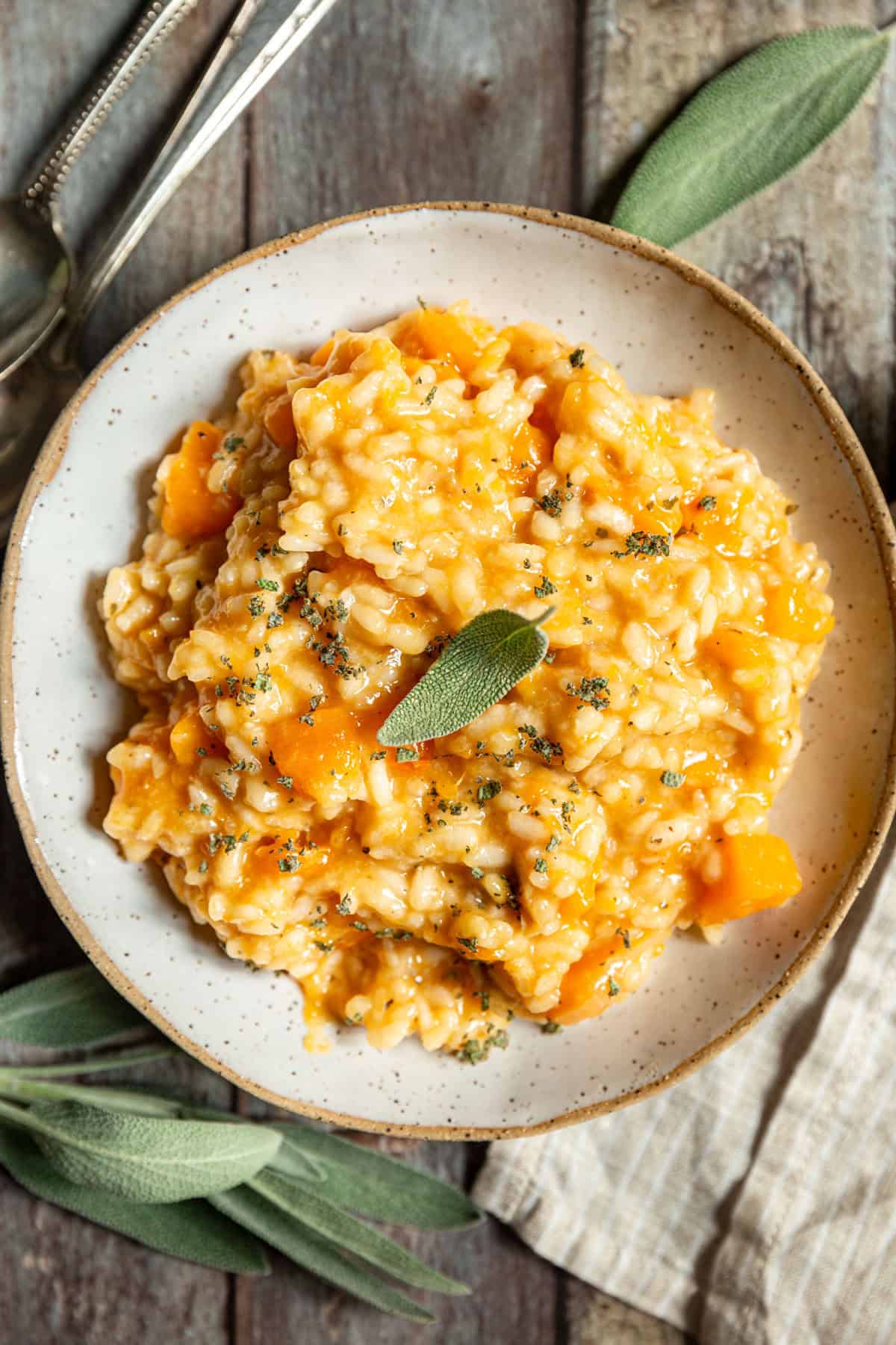 A bowl of Roasted Garlic and Butternut Squash Risotto garnished with sage.