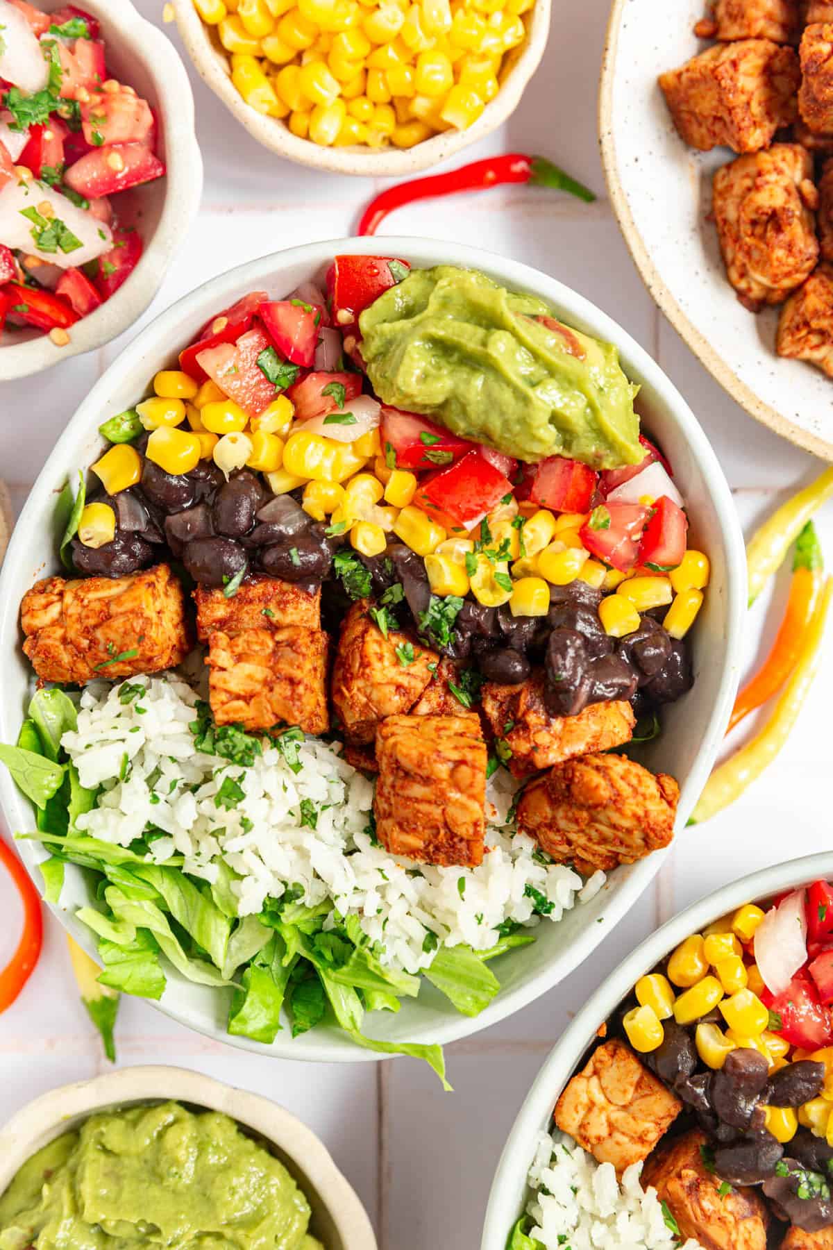 A tempeh burrito bowl loaded with veggies and toppings.