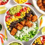 A tempeh burrito bowl loaded with veggies and toppings.