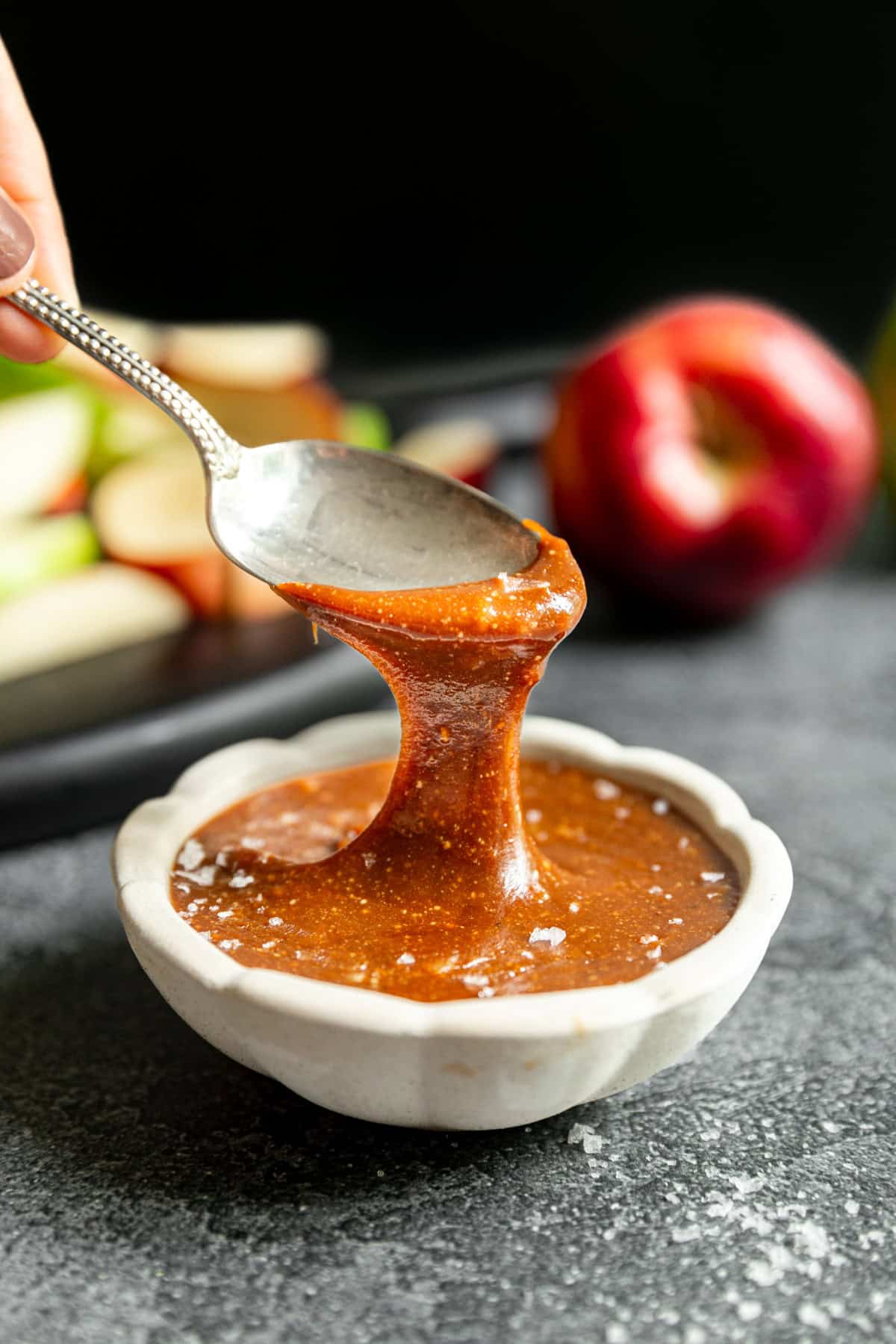 A spoon scooping a drizzle of vegan caramel.
