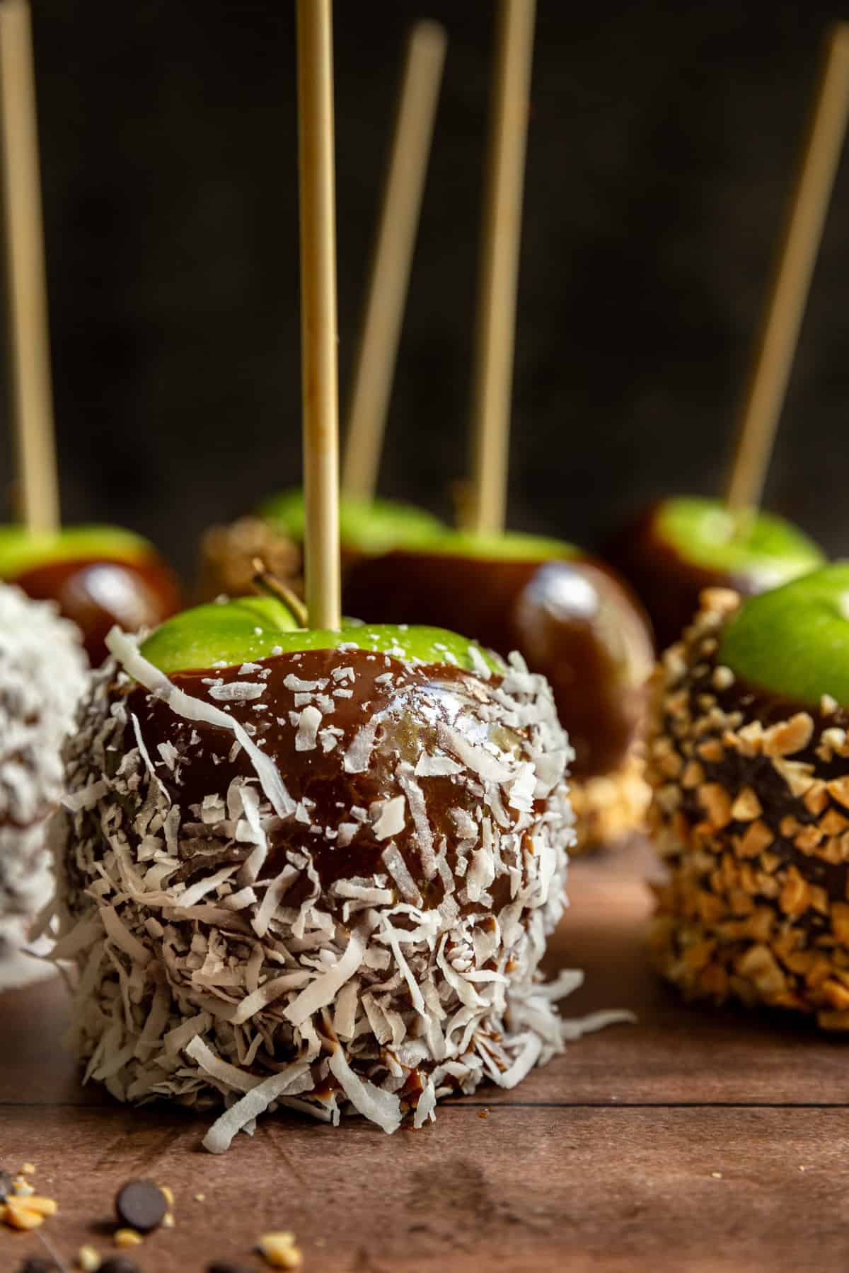 A vegan caramel apple covered in coconut flakes.