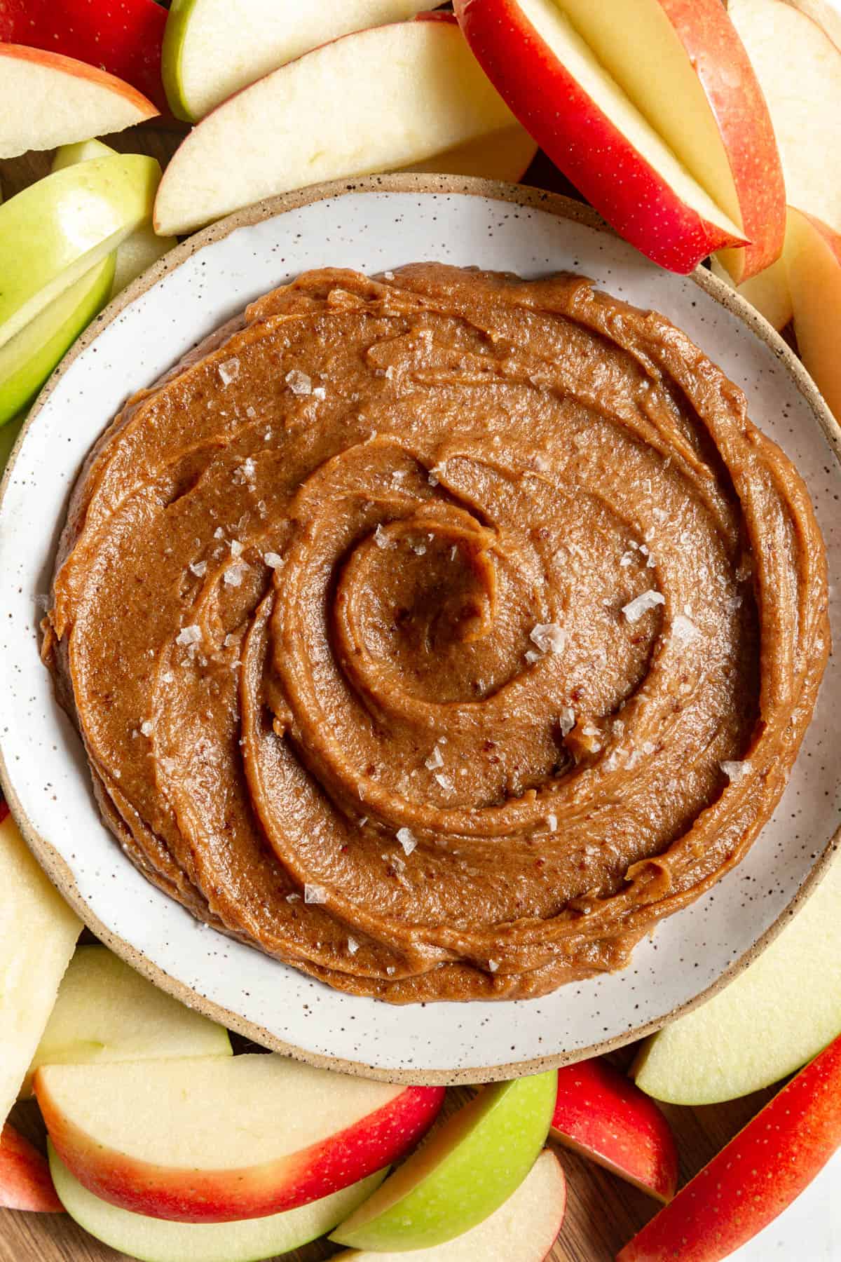 A tray of apples and a bowl of Vegan Date Caramel Sauce.
