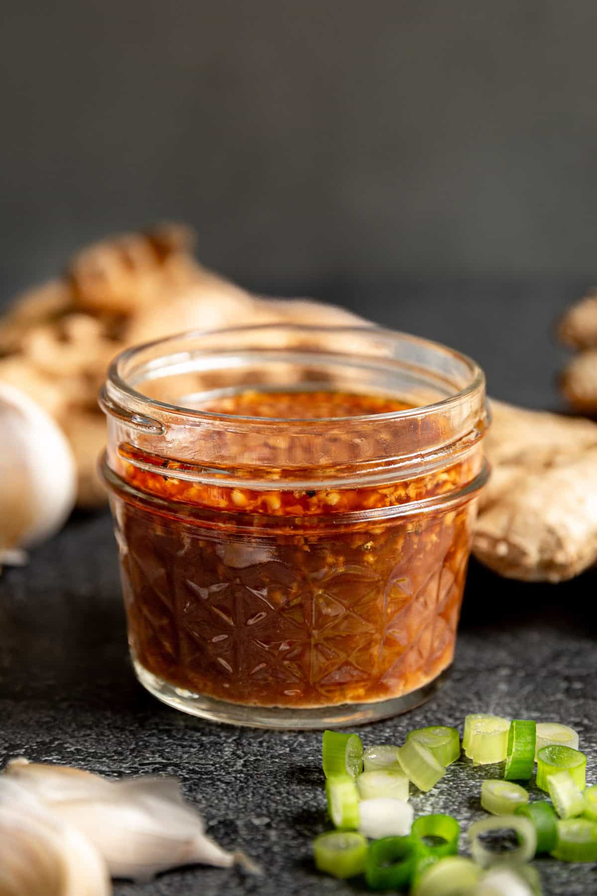 A jar of WFPB teriyaki sauce with scallions and ginger.
