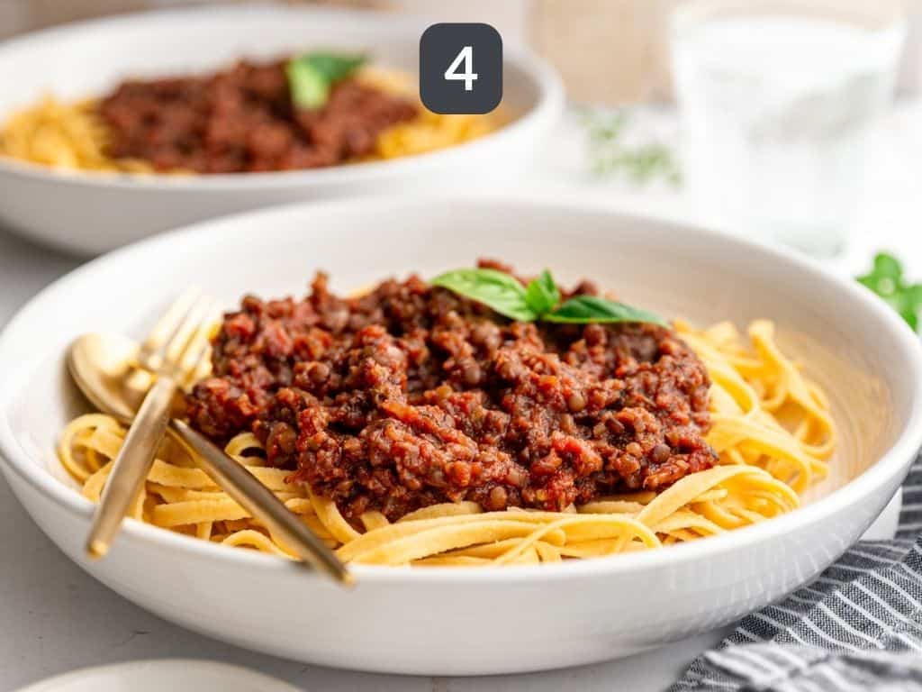 Black Lentil Bolognese Step 4 - serve with a garnish of fresh basil.