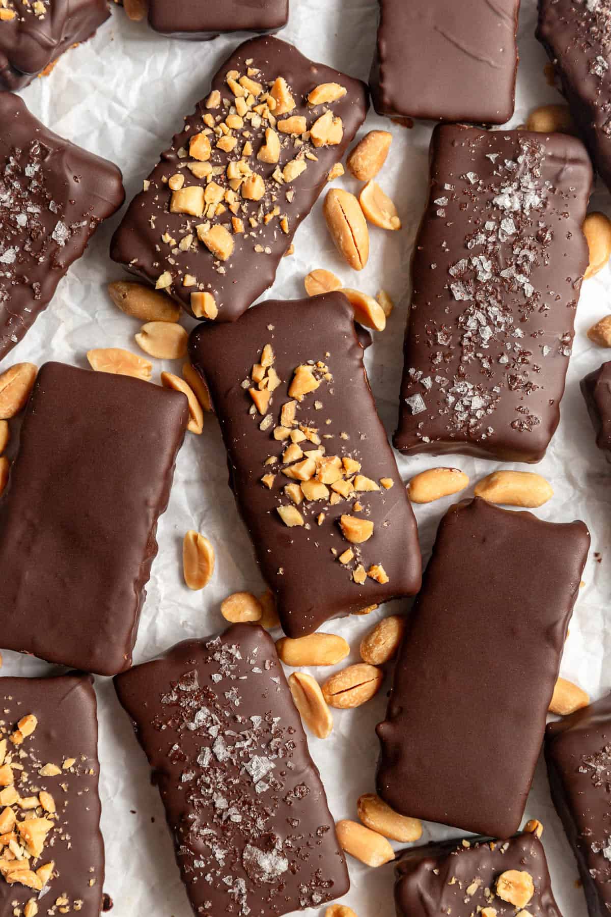 Several vegan butterfingers on a sheet of parchment paper, with peanuts.